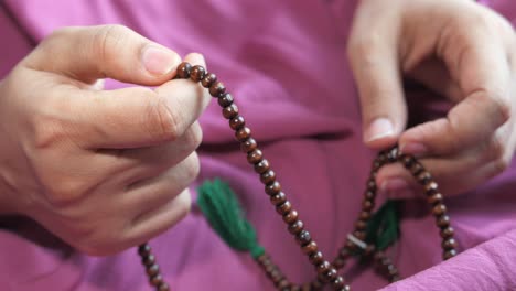person holding prayer beads