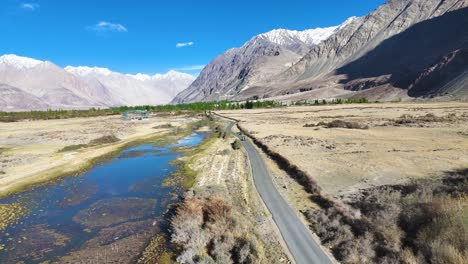 aerial drone shot offering a panoramic view of nubra valley’s blend of rugged terrain, riverbeds, and greenery.