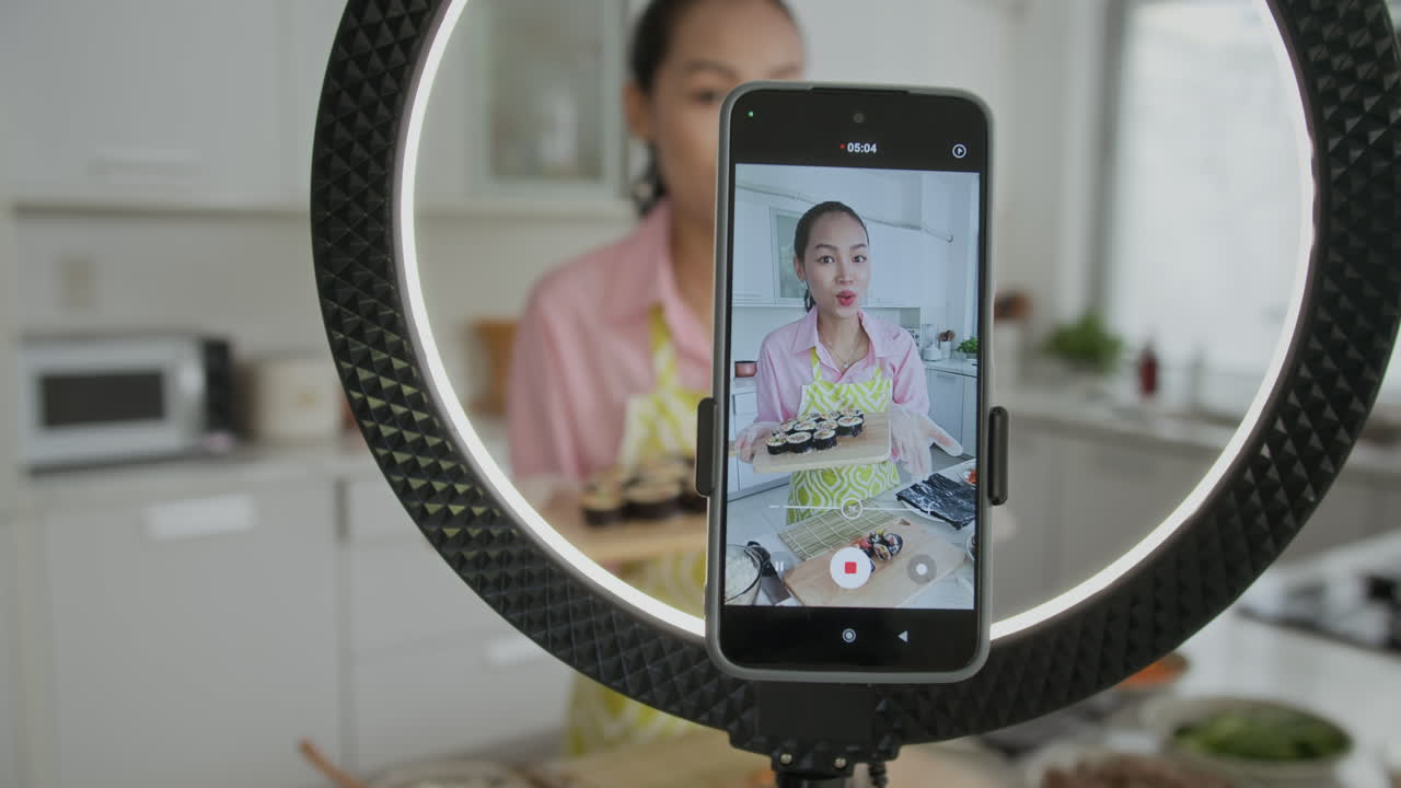 Donna asiatica che assaggia il kimbap vista attraverso uno smartphone
