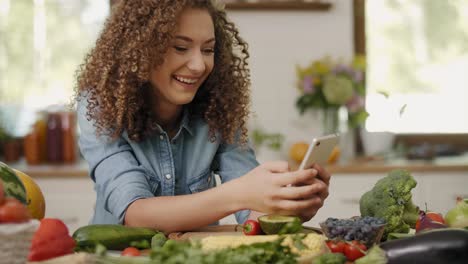 smiling woman with mobile phone in the kitchen/rzeszow/poland