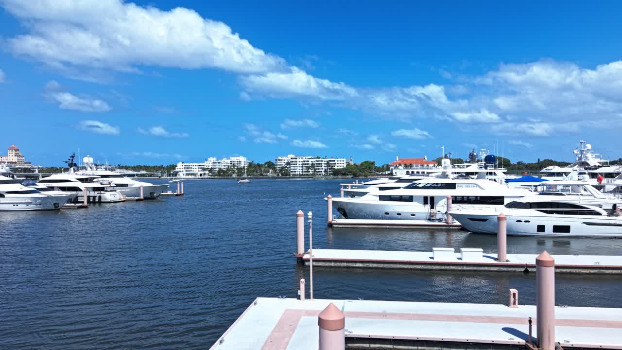 Low push in drone shot of white yachts in West Palm Beach marina during the day in Florida, USA