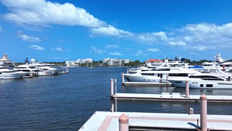 low push in drone shot of white yachts in west palm beach marina during the day in florida, usa