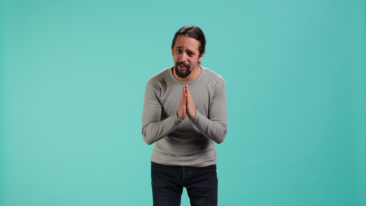 hombre juntando las manos en un gesto de mendicidad, pidiendo un favor