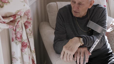 an elderly person with a crutch at home