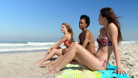 young female friends sitting together at beach 4k