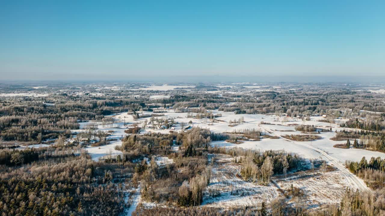 Breathtaking aerial panorama of snowy countryside and frosted forest landscape at winter sunrise. Drone winter hyperlapse. Clean environment.