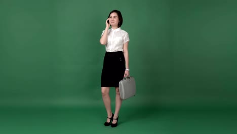 nice brunette woman in business clothes talking on the phone, chroma key green screen background