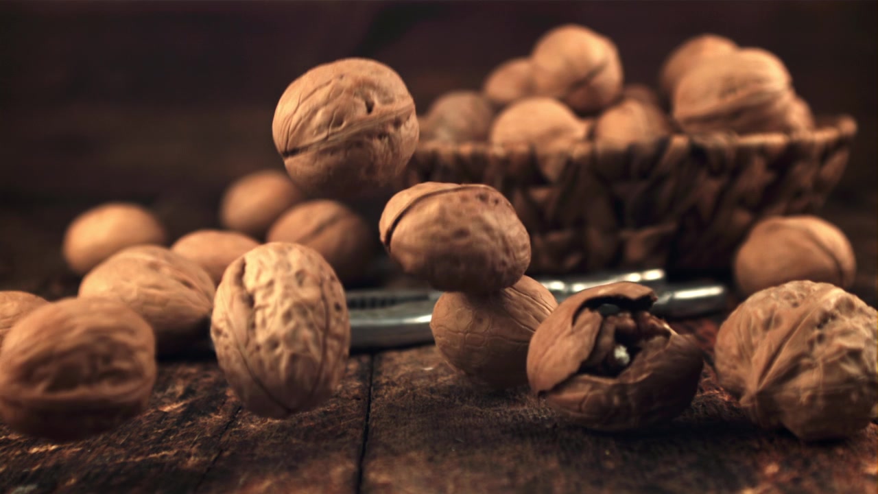 Walnuts Falling onto a Rustic Wooden Table in Slow Motion