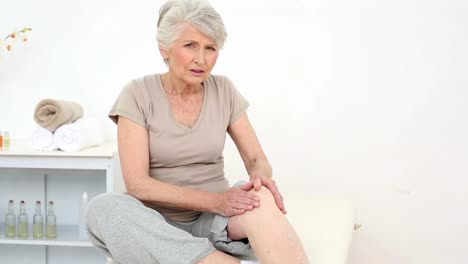 injured patient rubbing her sore knee