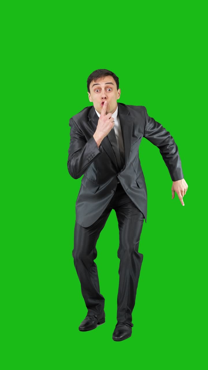 A man in a suit performing various gestures and expressions on a green screen
