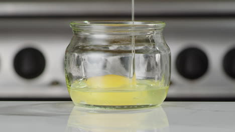 egg dropping into a jar in slow motion