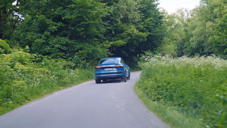 modern urban car riding on road. modern electric car rides through in cold blue style.