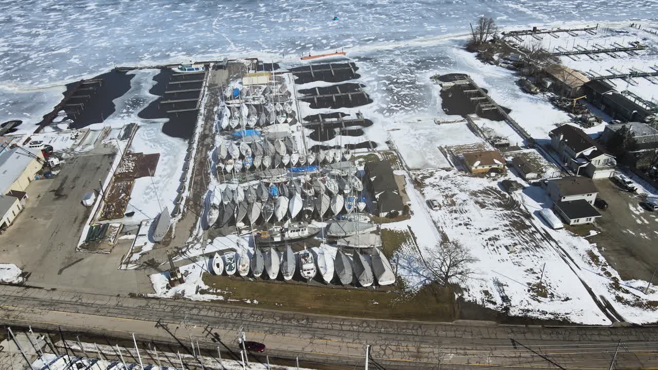 Panorering över vinterförvarade och förtöjda segelbåtar i februari