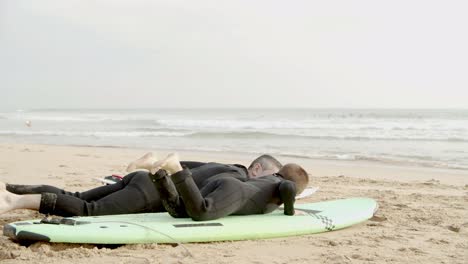 padre enseñando a su hijo pequeño a surfear