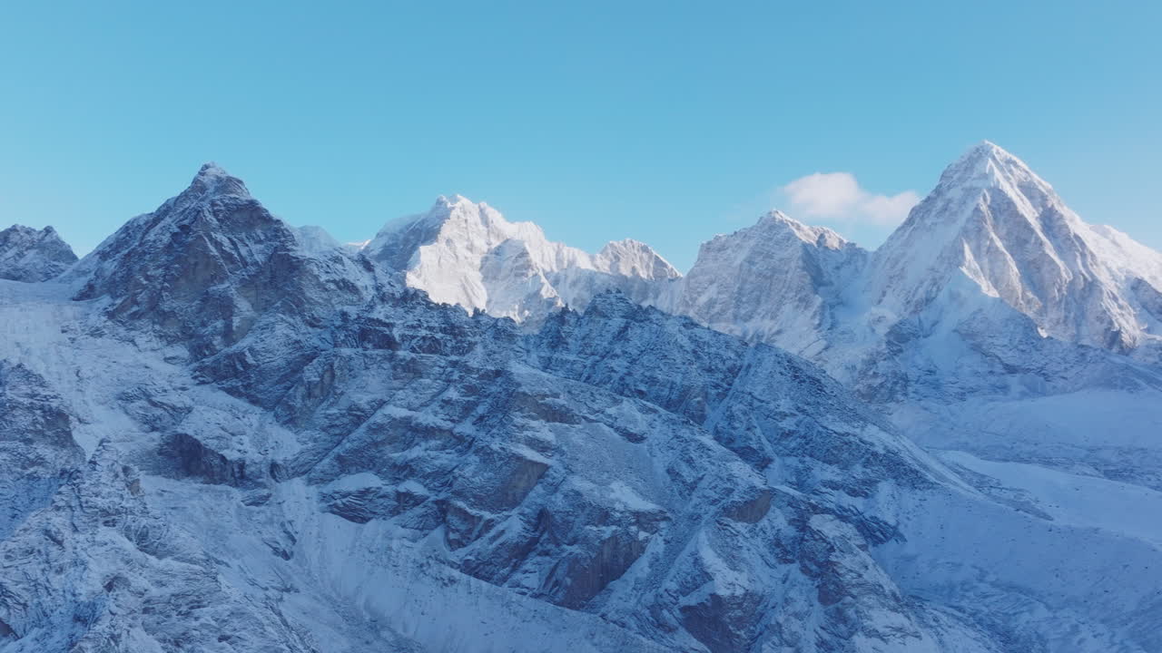 Aerial drone shot of Everest Base Camp trek in Khumbu region Nepal. Morning snowfall reveals Pumori, Lobuche, and Nuptse ranges shining under sunlight, a dreamy adventure with clear blue skies