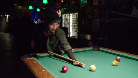 Young-woman-playing-pool-at-a-bar