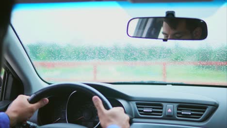 conductor en un coche en un día de lluvia