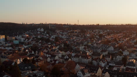 Aerial-evening-view-of-calm-small-spa-town.-Rising-footage-reveals-Frankfurt-am-Main-city-skyline-with-skyscrapers-on-horizon.-Bad-Vilbel,-Germany.