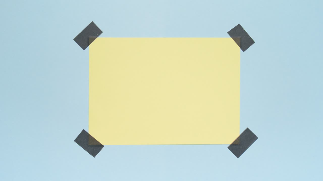Stop motion of yellow note appearing and taped to a blue background, creating clear copy space