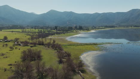 aerial perspective of aculeo lagoon in valparaíso, chile, showcasing the serene landscape, lush greenery, and tranquil water against a backdrop of mountains