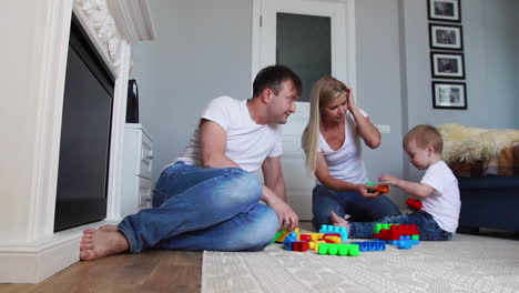 Glückliche-Familie,-Vater,-Mutter-Und-Baby-2-Jahre,-Die-In-Ihrem-Hellen-Wohnzimmer-Lego-Spielen.-Zeitlupenaufnahmen-Einer-Glücklichen-Familie