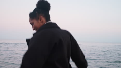 happy stylish african american girl running by the sea.