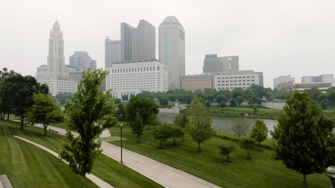 vista aérea del horizonte de columbus ohio desde el parque de génova a través de los árboles en un día de niebla y humo