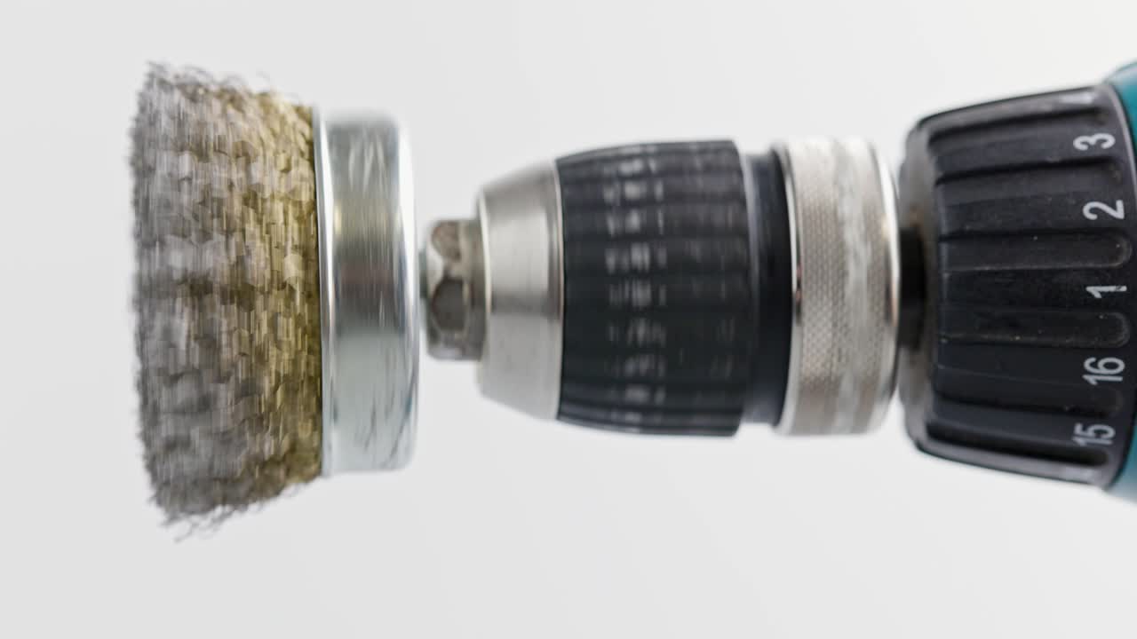 색 배경에 회전하는 둥근 강철 질을 가진 손 드릴