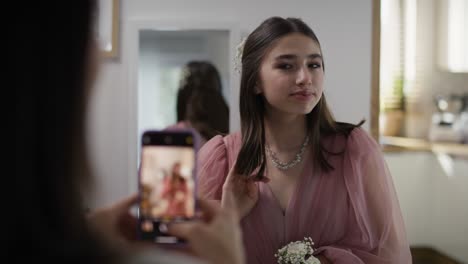 Mother-taking-picture-of-her-daughter-in-dress-before-prom-party