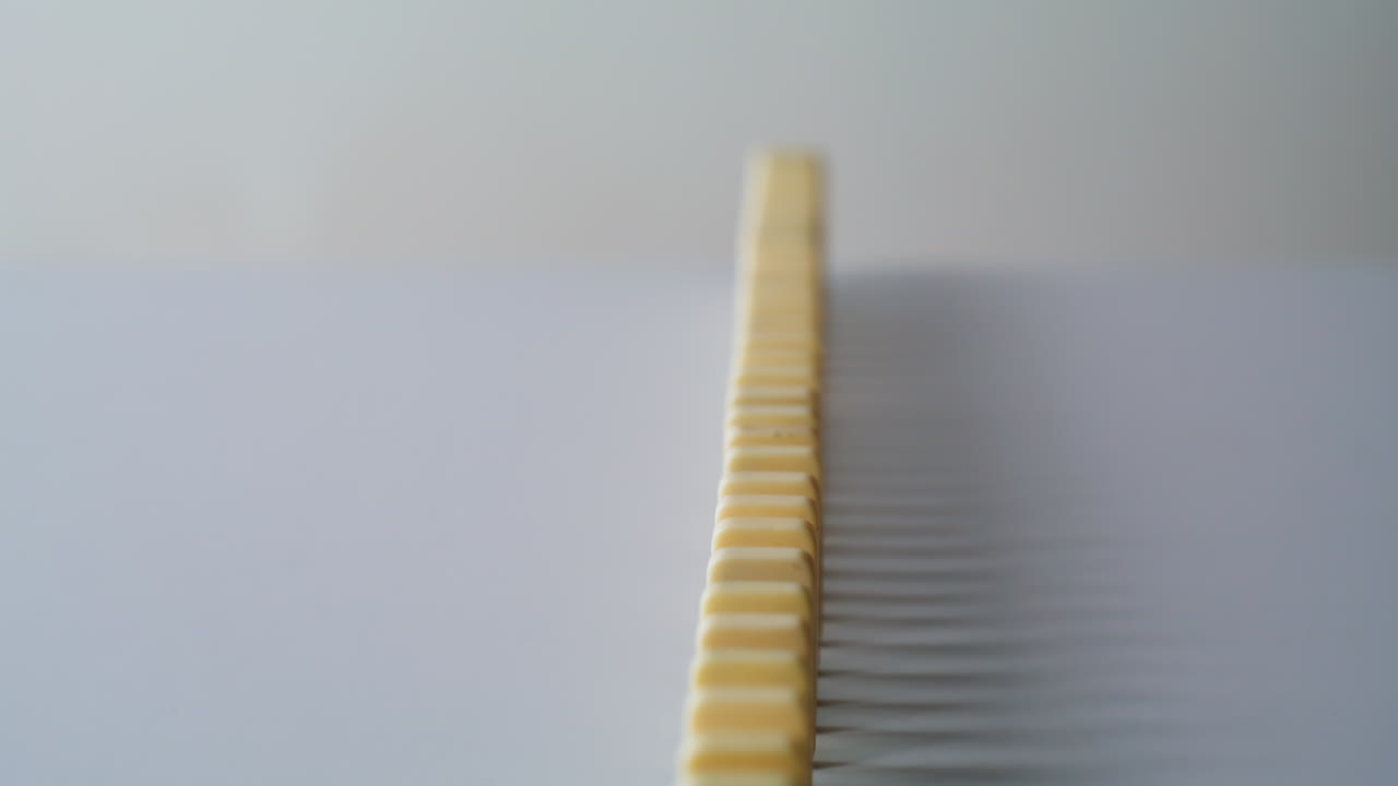 Domino pieces standing line on smooth surface indoors create sense of balance