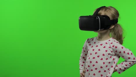 child girl using vr helmet to play simulation game app. watch virtual reality 3d video. chroma key