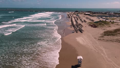 Disfrute-De-Impresionantes-Imágenes-En-4k-Tomadas-Con-Un-Dron-De-Una-Extensa-Playa,-Mientras-El-Dron-Avanza-Sobre-Suaves-Olas-Y-Costas-Arenosas.