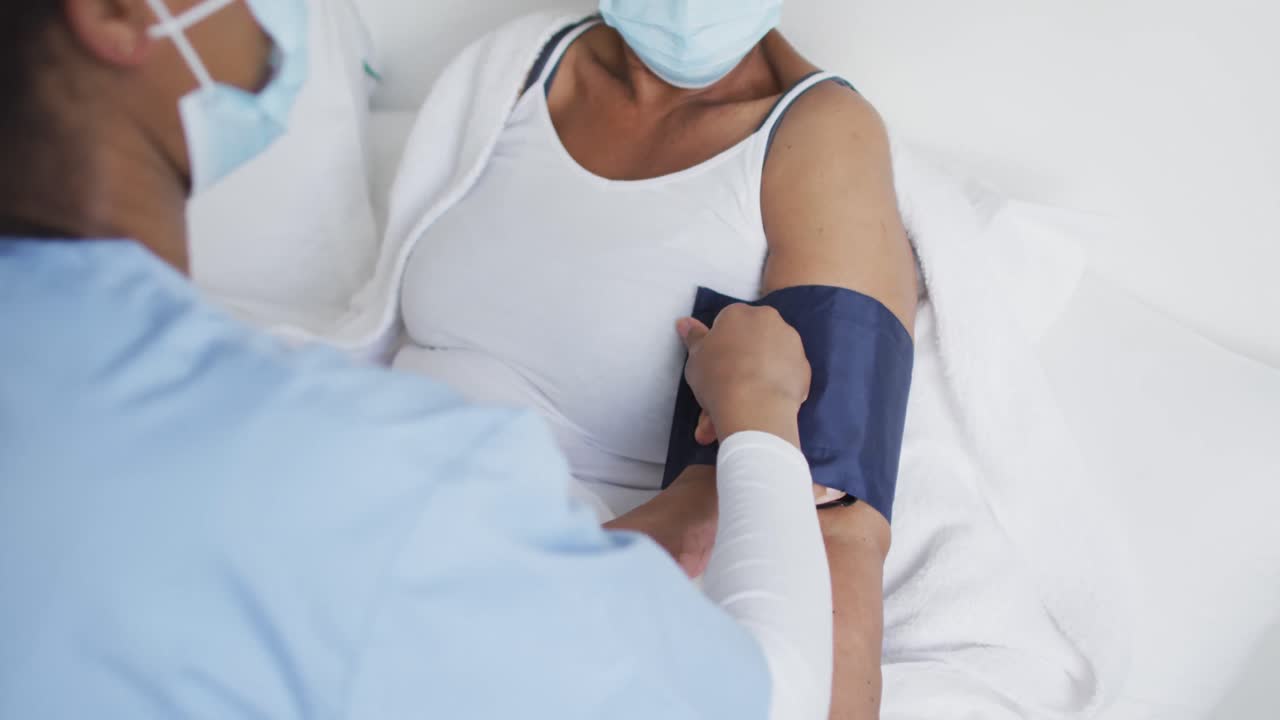 doctora afroamericana y paciente mayor con máscaras faciales