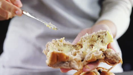 woman applying butter over multigrain bun 4k