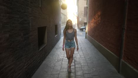 mujer caminando por un estrecho callejón de la ciudad