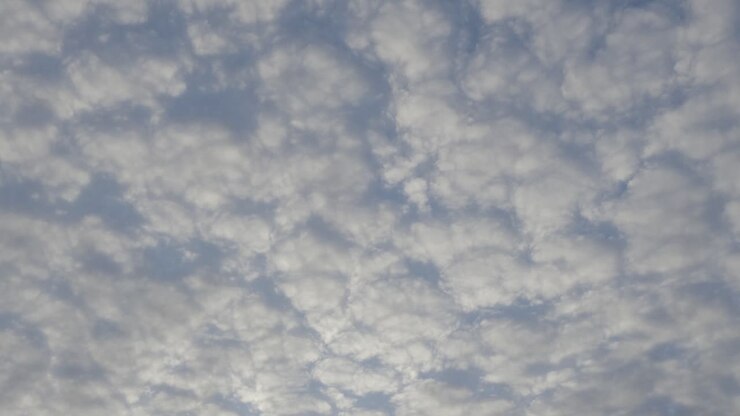 Perfectly fluffy white grey clouds lightly illuminated by sun, timelapse across sky