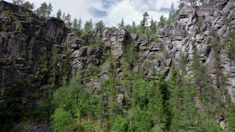 passing rocks and stubborn trees, a drone climbs up up out of the jutulhogget canyon in norway