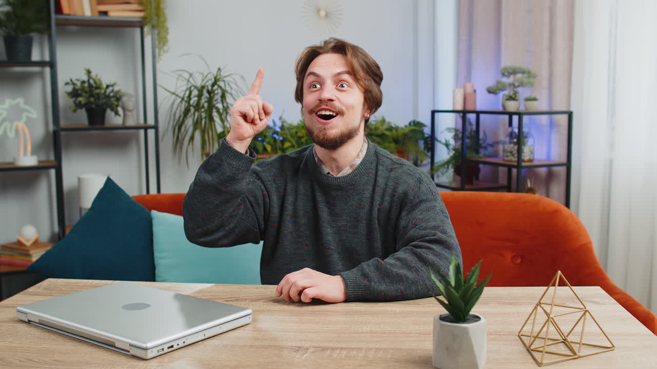 Thoughtful inspired caucasian man make eureka gesture raises finger came up creative plan at home