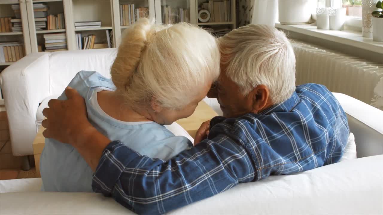 Coppia anziana che si scambia tenerezze in soggiorno