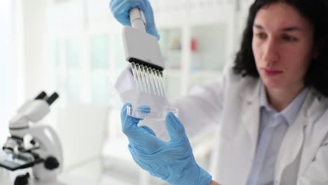 scientist working in laboratory with pipette and petri dish