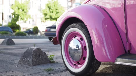 pink vintage volkswagen beetle on the street