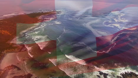 digital composition of waving switzerland flag against aerial view of sea waves