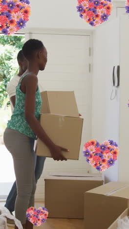 animation of heart icons with flowers over african american couple moving house