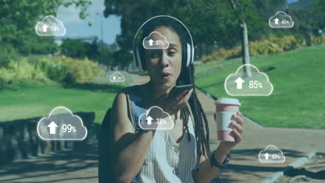 animación de nubes con flechas sobre mujer hablando en un teléfono inteligente en un parque