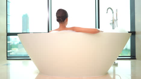 back of sensual woman in bathtube with foam in slow motion