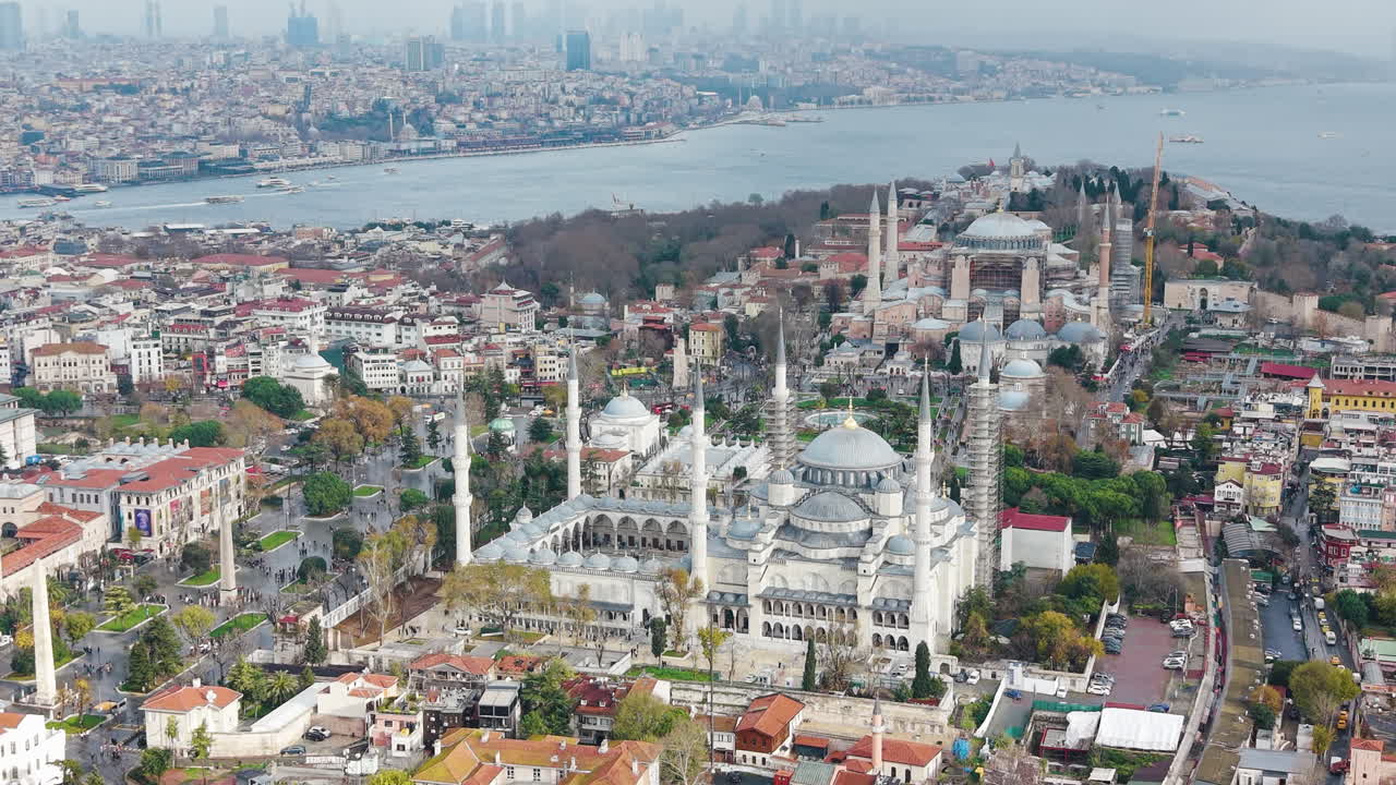 Vista aérea del barrio de Sultanahmet en Estambul, donde se puede apreciar la Mezquita Azul y Santa Sofía, rodeadas de calles históricas y la vida de la ciudad. Monumentos emblemáticos y patrimonio cultural de Turquía
