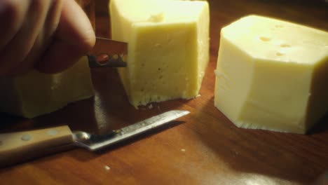 soft focus closeup: glowing cheese on cutting board sliced with knife