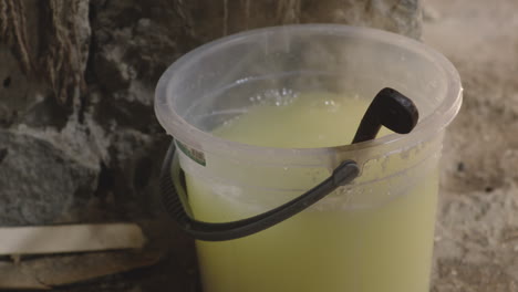 filling a scoop of hot water, cheese making process, chobareti georgia, close up