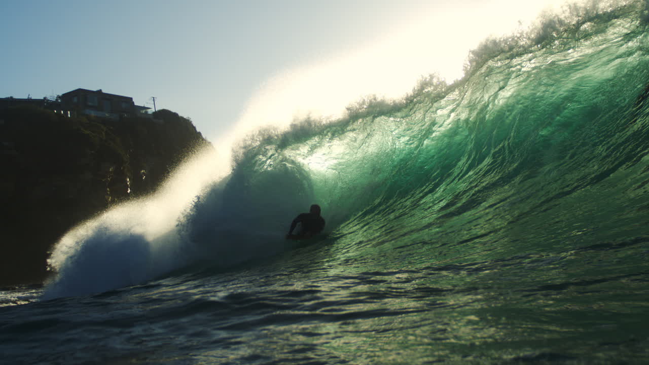 Dramatic sunrise wave explodes on reef at Whaley Wedge in slow motion with rainbow mist