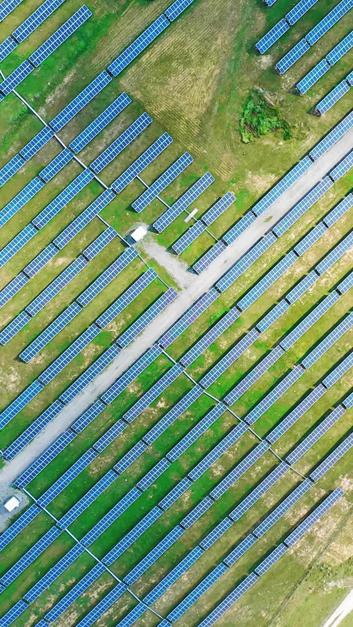 Ecological power plant in summer. Top view on the solar panels on the field. Renewable energy. Alternative source of electricity. Aerial view. Camera moves around. Vertical video